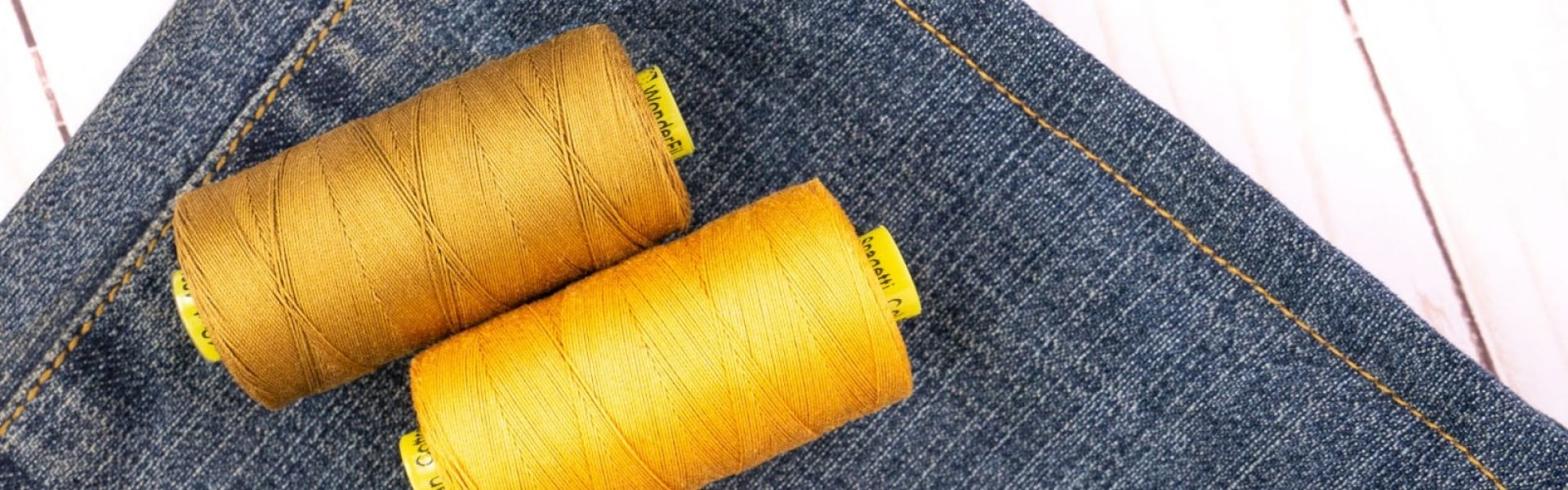 A photo of Spagetti 12wt cotton thread and a pair of hemmed jeans.